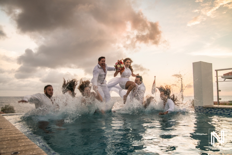 Bridal party jumping pool with sunset