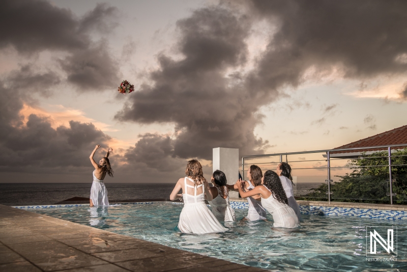 Bride trowing bouquet at pool with sunset