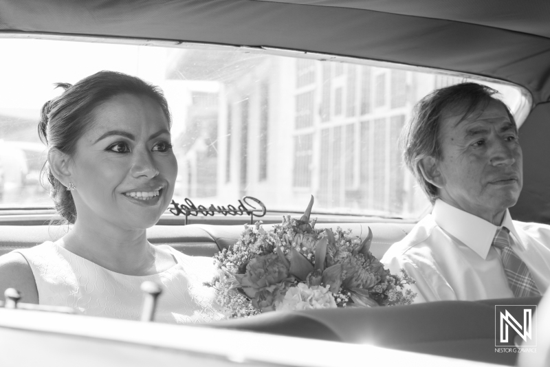 Bride and Father of the bride sitting on car