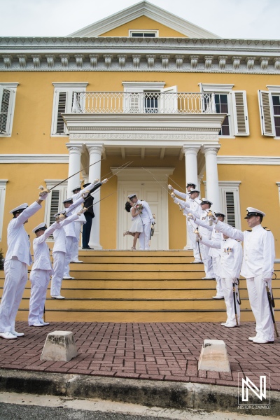 Bride and Groom kissing  with tunnel of navy swords