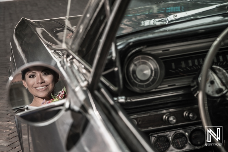Bride smiling on old black cadillac mirror