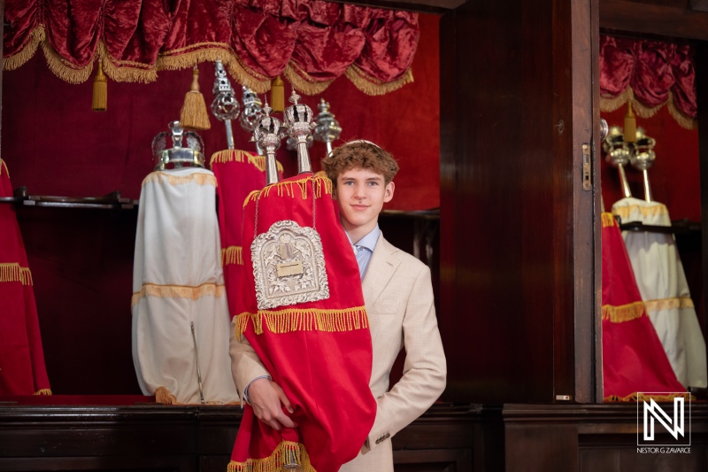 Celebration of bar mitzvah at mikve israel-emanuel synagogue in curacao with torah scroll