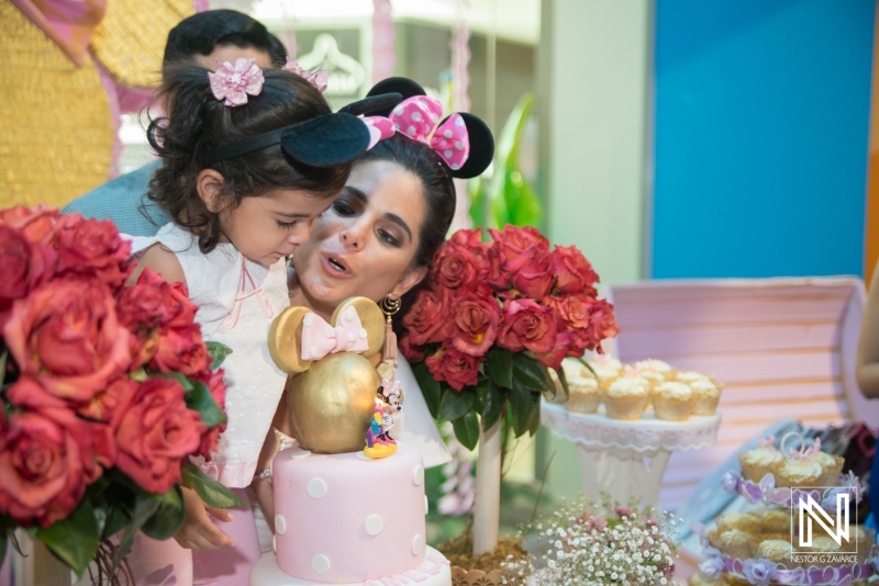 Celebration at a birthday party in Curacao with cake, flowers, and joyful moments between a child and parent