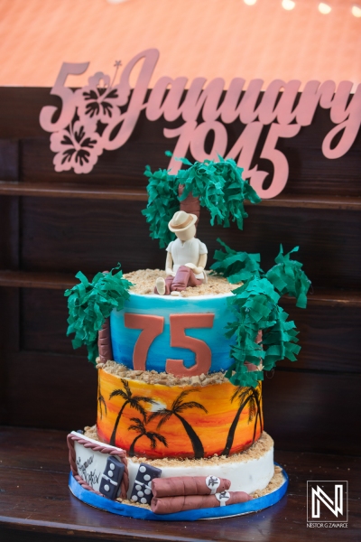 Birthday celebration for a 75-year-old in Curacao featuring a vibrant tropical cake with beach motifs and palm trees