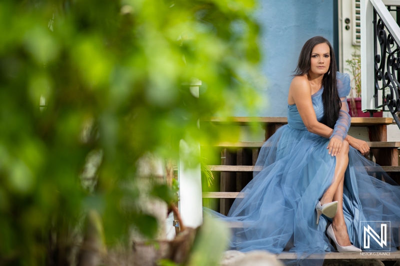 Elegant birthday celebration in Curacao featuring a woman in a stunning blue dress sitting gracefully on steps