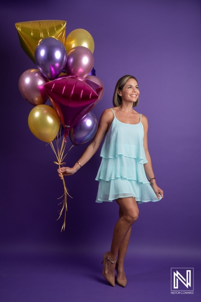 Celebrating a birthday in Curacao with vibrant balloons and a cheerful ambiance marked by a playful, light blue dress