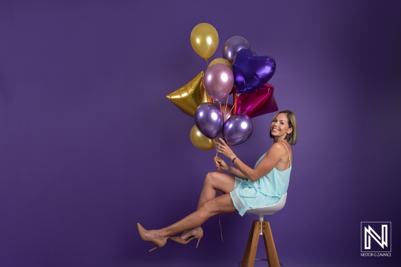 Celebrating a birthday in Curacao with colorful balloons and joyful expression in a vibrant setting