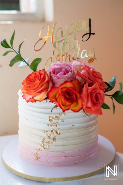 Celebrating a special birthday in Curacao with a beautiful cake adorned with fresh flowers and a festive topper