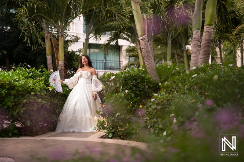 Celebration of a birthday in Curacao with a joyful woman in a beautiful white dress surrounded by lush greenery and colorful flowers