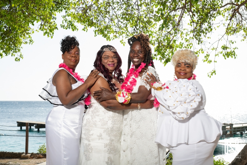 Family celebration in Curacao for a birthday with friends in elegant white outfits near the beach waters