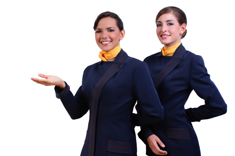 Two smiling airline crew members dressed in formal uniforms pose confidently in a bright indoor setting in Venezuela, showcasing professionalism and hospitality