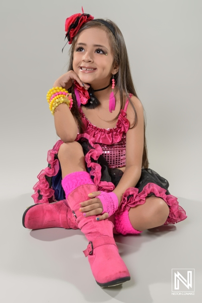 Brightly dressed child posing with flair in a colorful outfit showcasing a spirited expression in a lively commercial setting