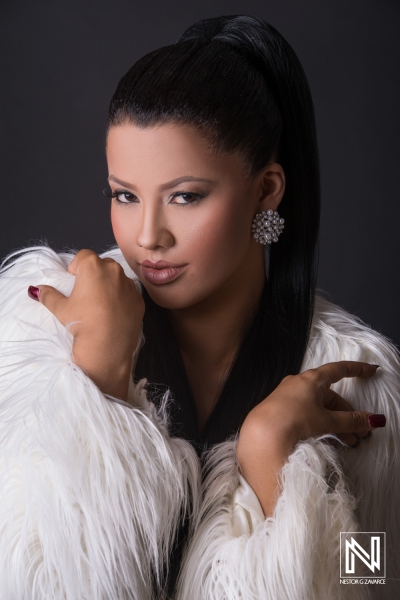 Elegant model showcasing fashion inspiration in a dramatic pose against a dark backdrop in Curacao