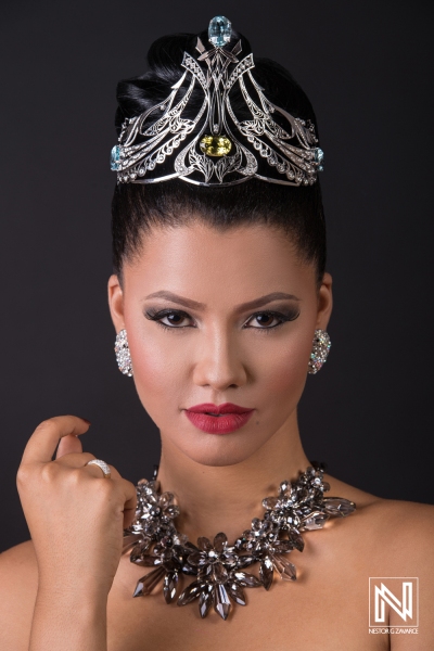 Model showcases elegant jewelry and crown design in a dramatic portrait set against a dark background in Curacao