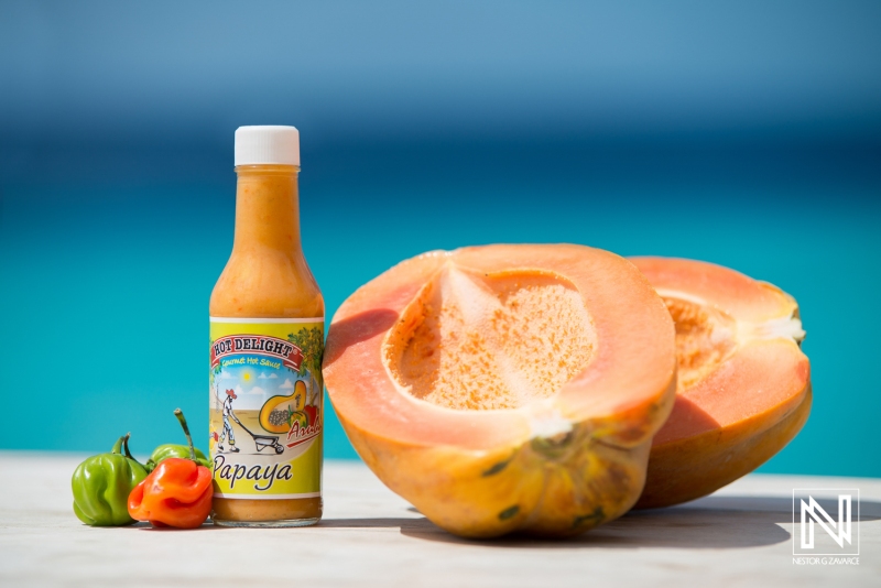 Papaya and hot sauce on display against stunning turquoise waters in Curacao showcasing local flavors and vibrant produce