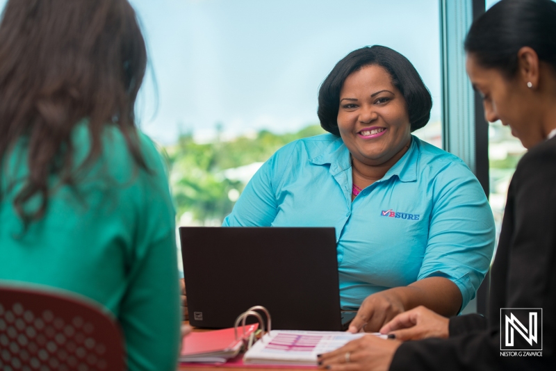 Professional collaboration in Curacao office setting with a cheerful team member assisting clients during a business meeting