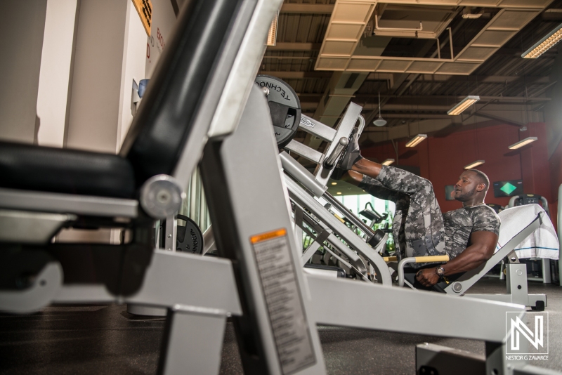 Man exercising on leg press machine in a modern gym in Curacao promoting health and fitness