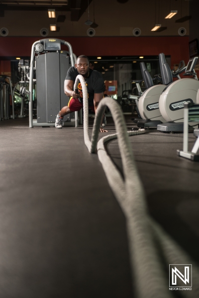 Fitness enthusiast training with battle ropes in a modern gym setting in Curacao during a morning workout session