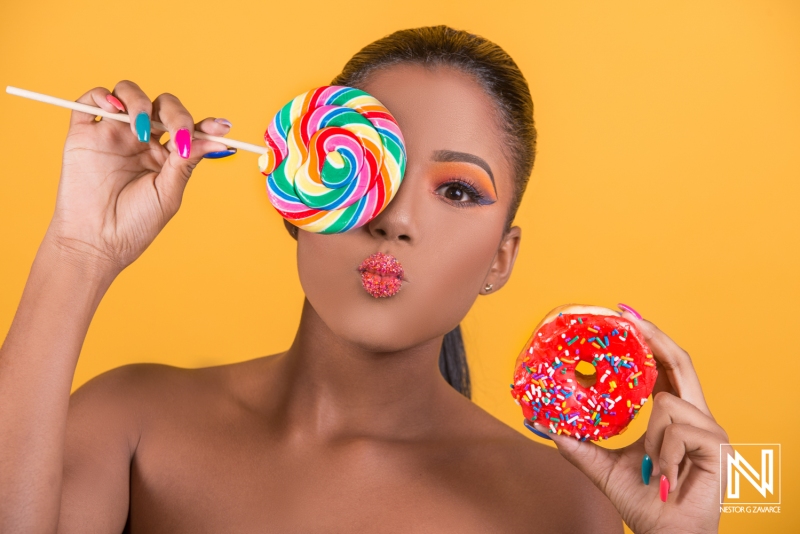 Colorful candy creations featuring vibrant model with lollipop and donut in Curacao commercial setting