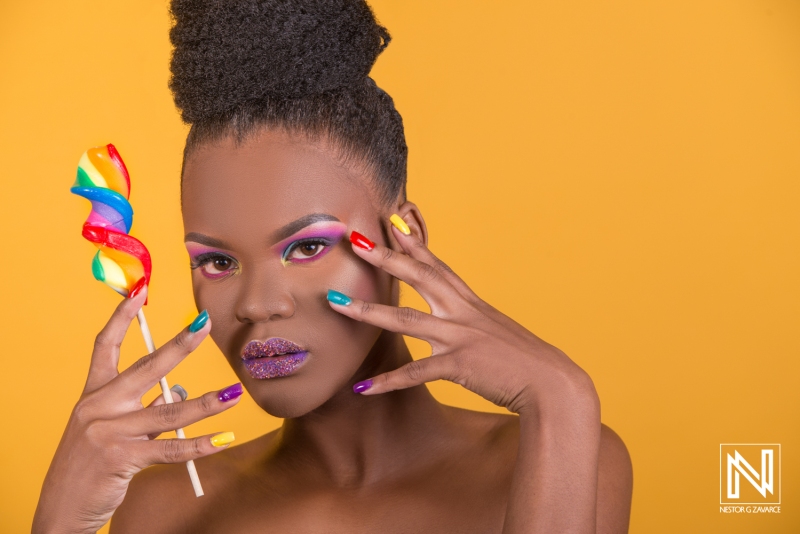 Vibrant beauty campaign featuring a model with colorful nails and makeup holding a multicolored lollipop set against a bright backdrop