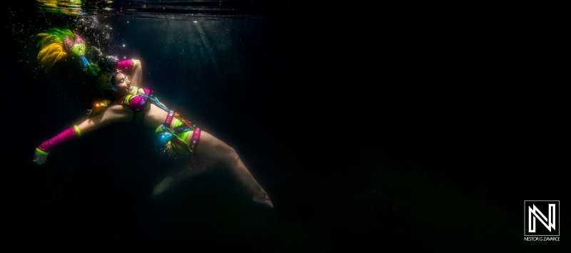 Colorful underwater dancer showcasing vibrant costume in Curacao's serene waters during a commercial shoot