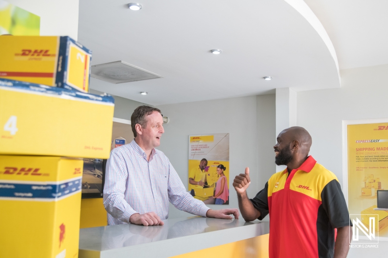 Shipping service professionals engage in conversation at a location in Curacao while handling packages during the day