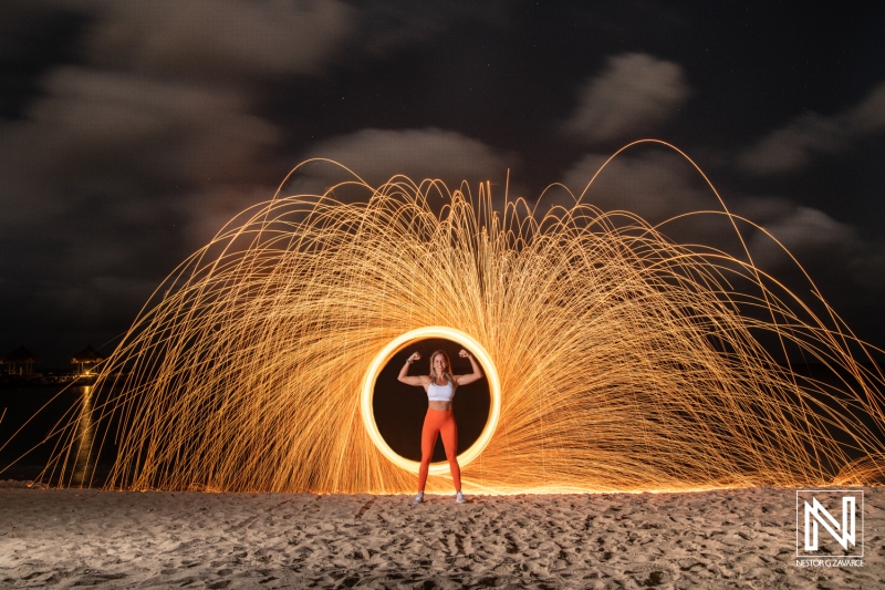 Creative steel wool spinning demonstration on Curacao beach at night showcasing vibrant light effects