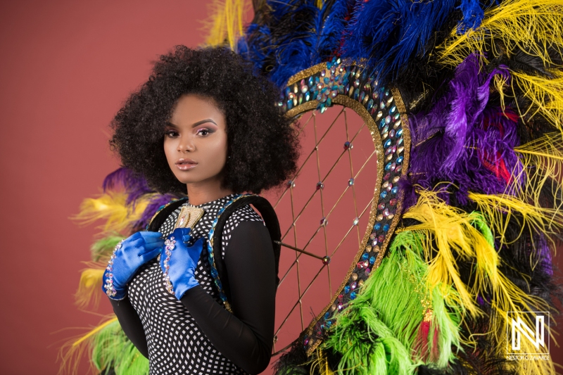 Model poses elegantly in vibrant costume with feathers and beads in Curacao during a lively commercial shoot emphasizing cultural celebration