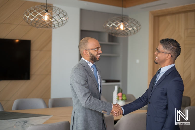 Two business professionals shake hands in a modern office setting in Curacao during a brand partnership meeting