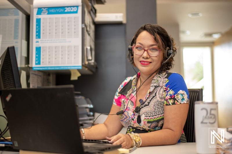 Professional at a desk in Curacao's commercial environment, engaged in providing support with a headset and laptop