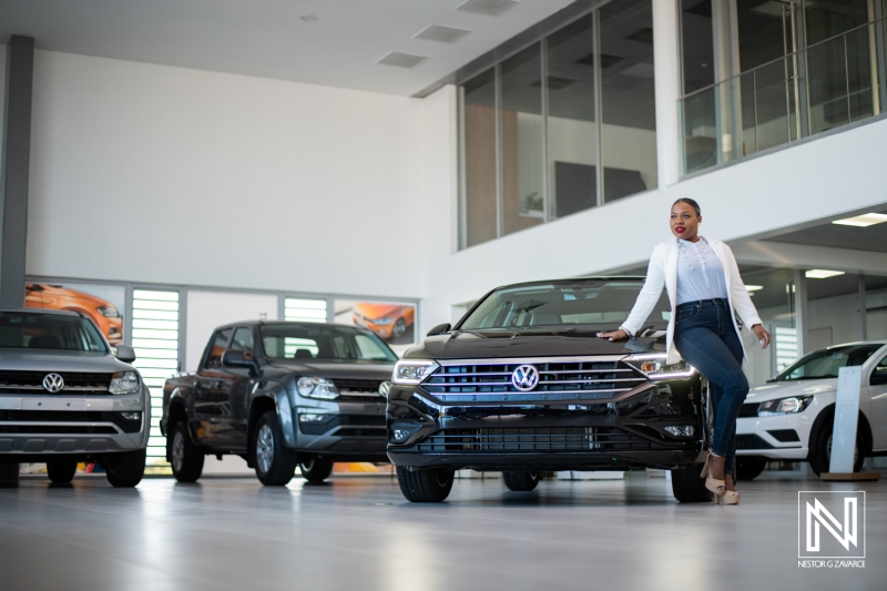 Showroom display of modern vehicles in Curacao with a model showcasing the latest features in a sleek automotive environment