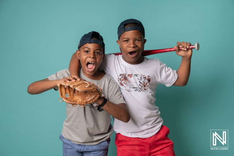 Two boys celebrate their passion for baseball in Curacao with enthusiasm and playful energy, capturing the joy of youth sports