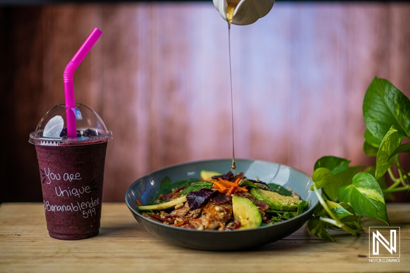 Delicious tropical salad and refreshing drink served in Curacao's vibrant culinary scene