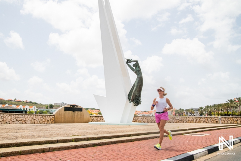 Runner enjoying a sunny day by the waterfront in Curacao with a striking sculpture in the background