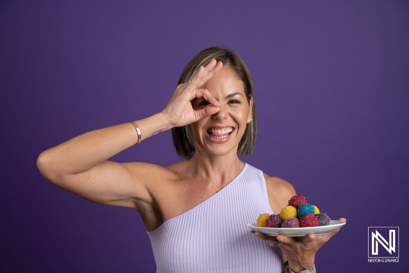 Delightful woman enjoying colorful treats with joy in a vibrant setting in Curacao during a commercial shoot