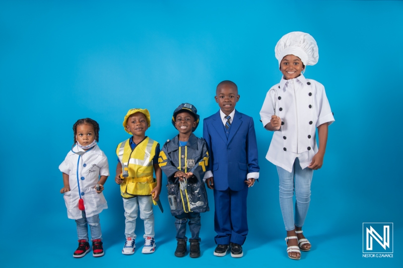 Children dress up in various professions featuring vibrant costumes in a bright blue background showcasing Curacao's culture and creativity