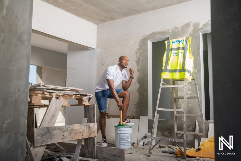 Construction worker in Curacao engages in renovation task while showcasing brand awareness in a commercial setting