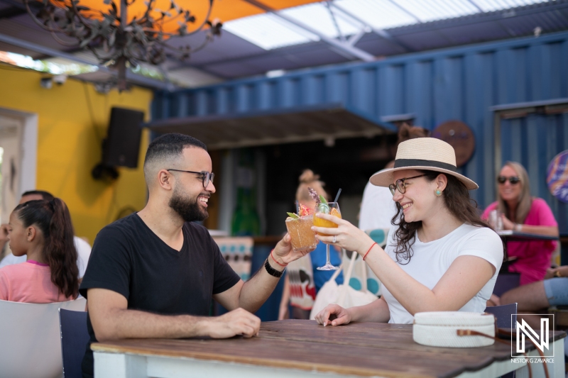 Enjoying tropical drinks at a vibrant cafe in Curacao with friends, capturing the essence of relaxation and joy