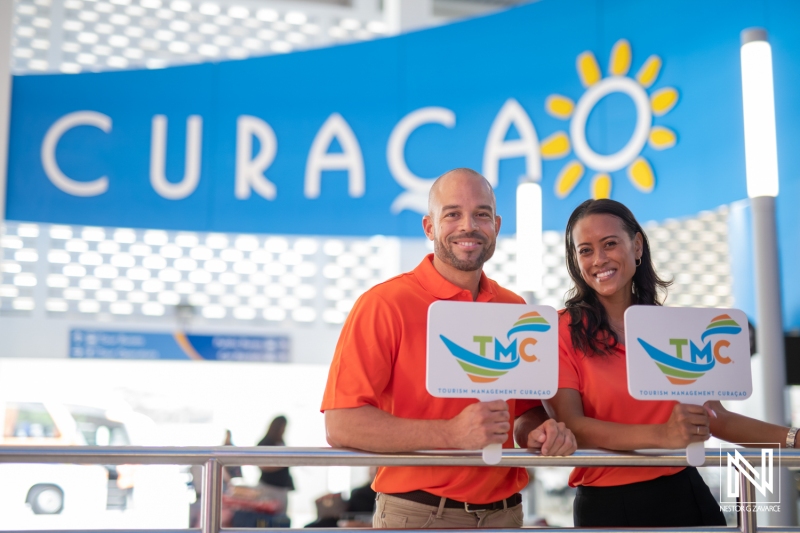 Tourism representatives promote travel opportunities in Curacao with welcoming smiles and informative signs