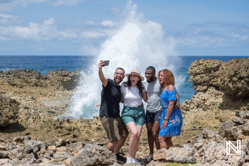 Group of friends taking a selfie at the scenic coastline of Curacao on a sunny day