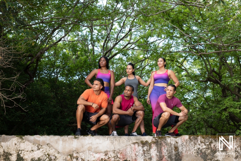 Group of fitness enthusiasts posing outdoors in Curacao surrounded by lush greenery during daytime