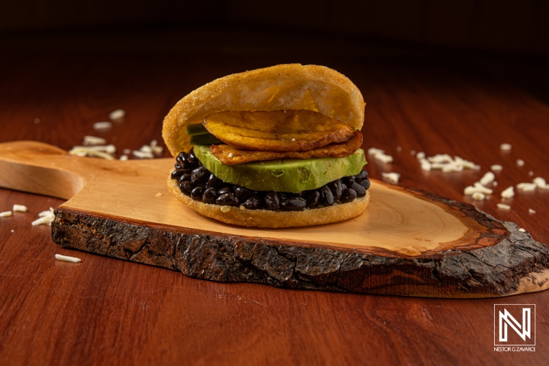 Curacao’s unique dish featuring black beans, avocado, and fried plantains served on a wooden board in a warm and inviting setting