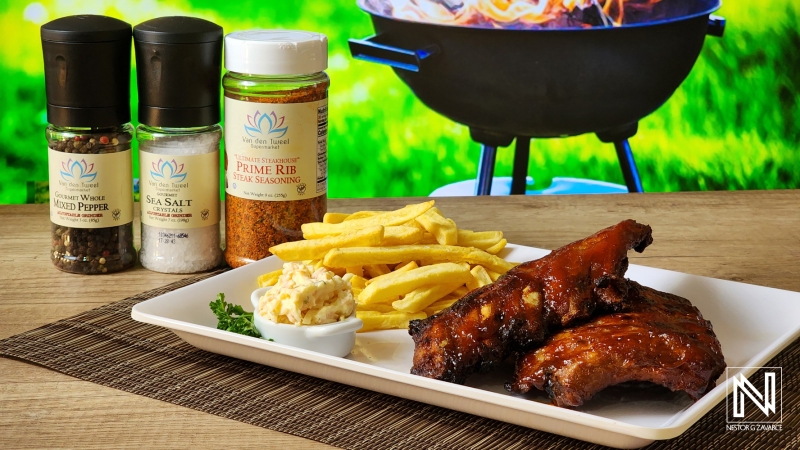 Delicious barbecue ribs served with fries and sides in a vibrant outdoor setting in Curacao