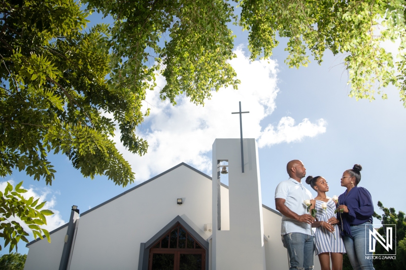 Family gathering outside a church in Curacao, celebrating a special occasion with joy and togetherness