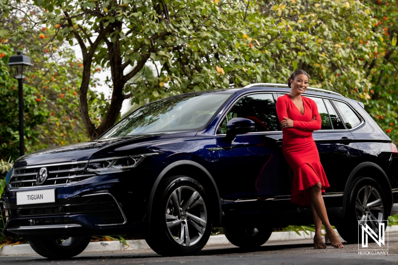 Promoting a stylish SUV in Curacao with a confident model in striking red attire beside the vehicle