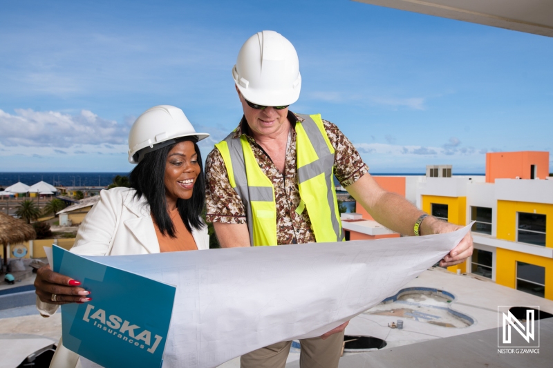 Professionals collaborate on a construction project in Curacao with plans in hand