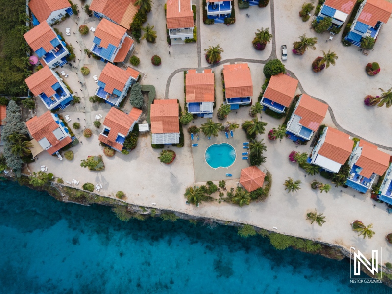 Vibrant coastal resort in Curacao featuring colorful buildings and a refreshing swimming pool surrounded by palm trees