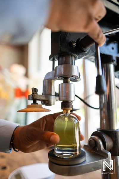 Creating a unique perfume bottle at ParfumLab in Curacao using a manual filling machine during a branding session