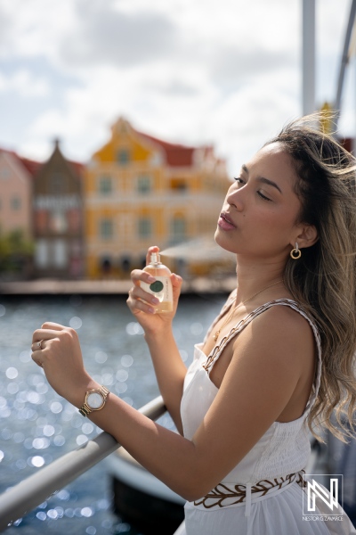 Product photoshoot for ParfumLab in Curacao featuring a model by the water with colorful buildings in the background