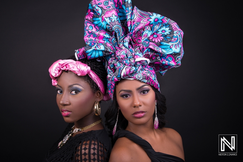 Two Women With Vibrant Headwraps Pose Confidently Against a Dark Background, Showcasing Their Unique Styles and Cultural Heritage During a Photoshoot